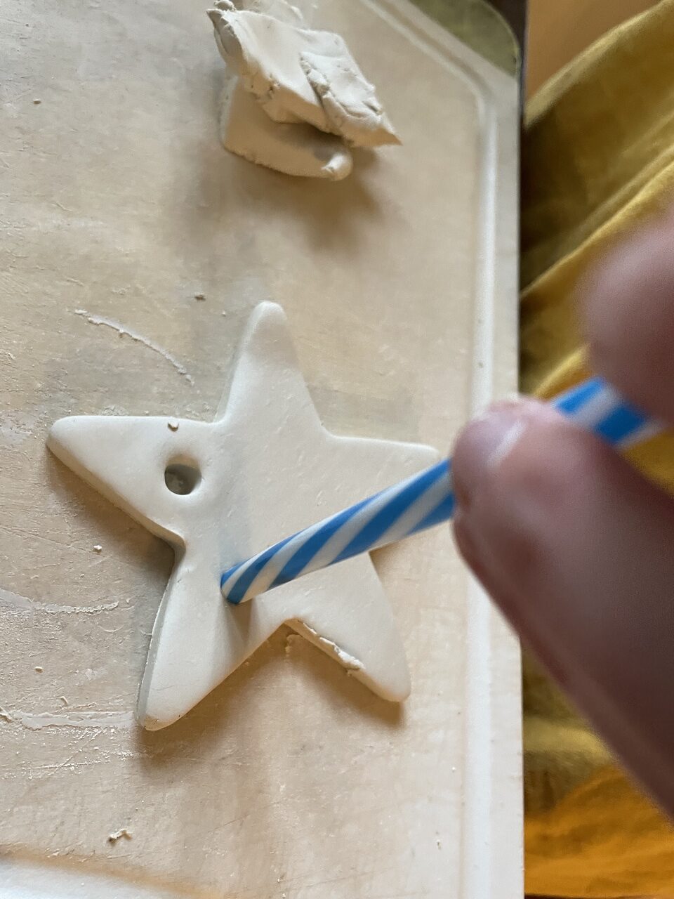 straw poking into clay frog