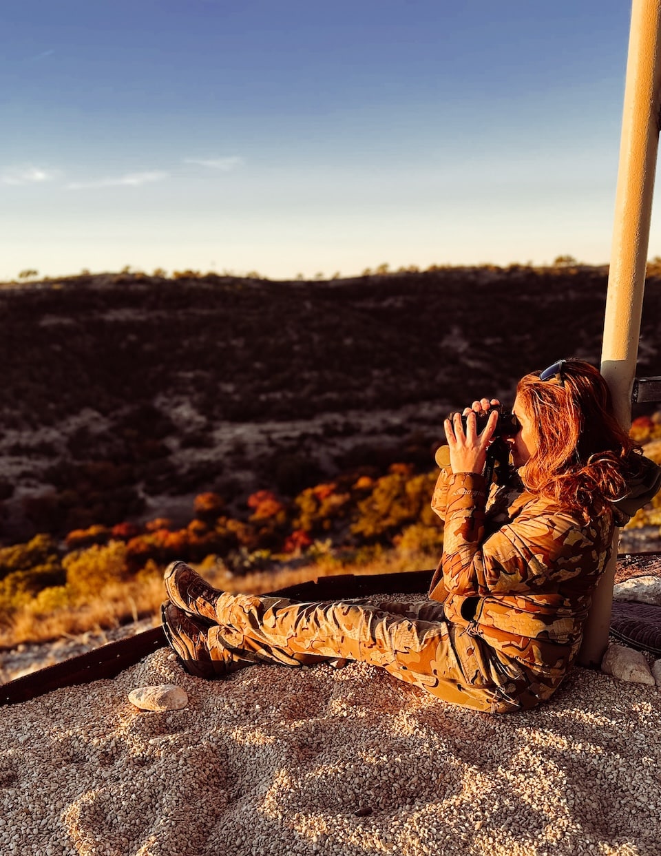 woman hunter glassing at sunrise