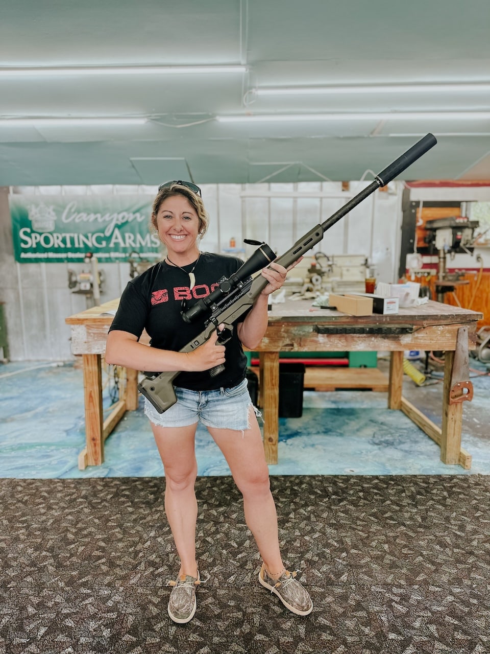 Andrea Bogard with rifle in shop Andi Bogard