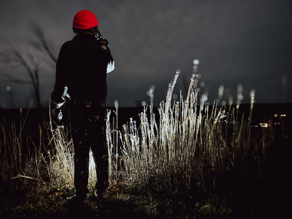 Young man looking for animals with a thermal monocular