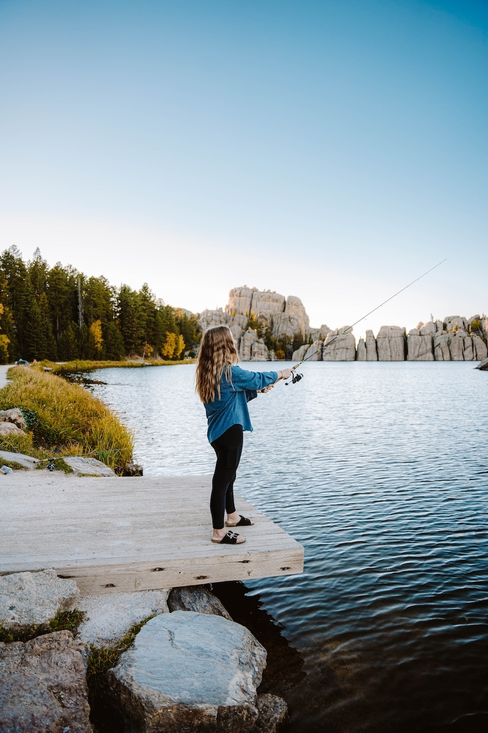 Woman fishing from platform at Sylvan Lake