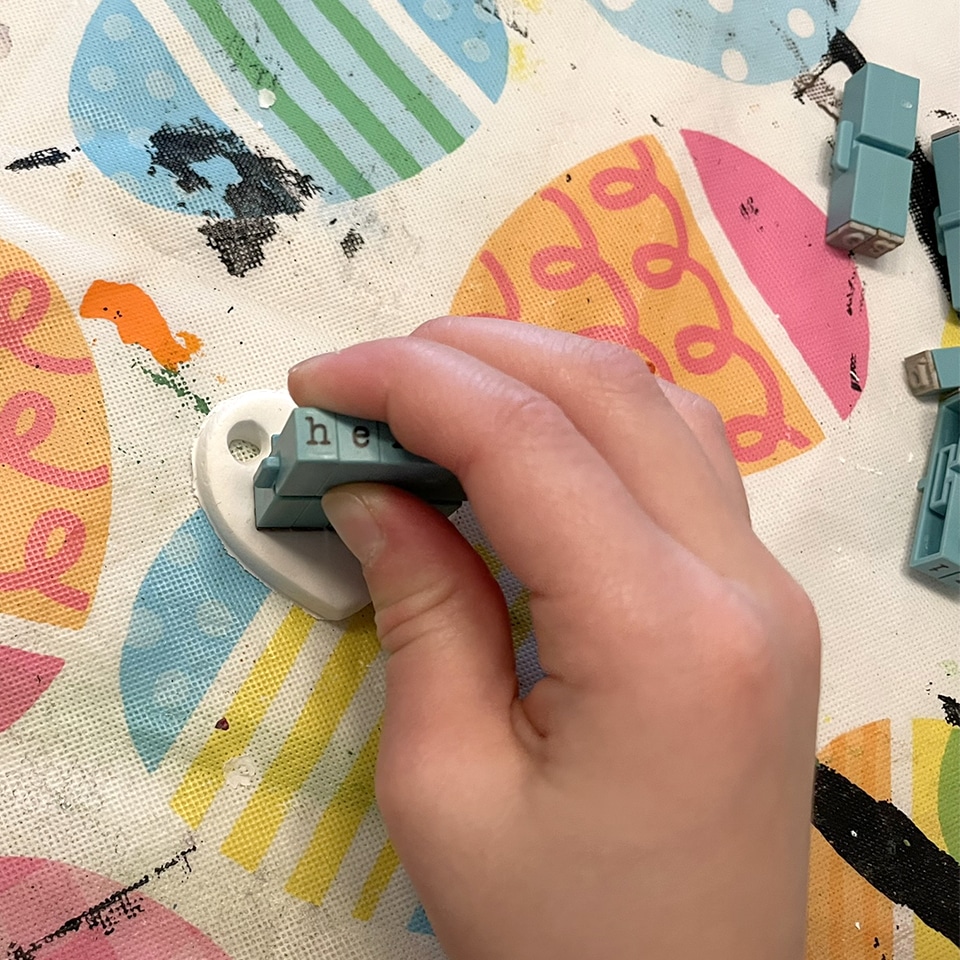 Stamping letters on clay conversation hearts