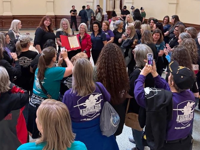 Robyn Sandoval read the resolution to the AG & AG members gathered in the Rotunda. Dozens of A Girl & A Gun members traveled from across Texas to celebrate this milestone.